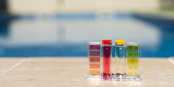 Close-up of a pool water testing kit with reagent bottles and color comparator, used for measuring pH and chlorine levels in a backyard swimming pool - pool maintenance concept