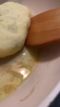  Perfect golden-brown crust! Close-up of flipping potato zrazy (stuffed potato pancakes) in a frying pan with oil. Cozy home cooking video.