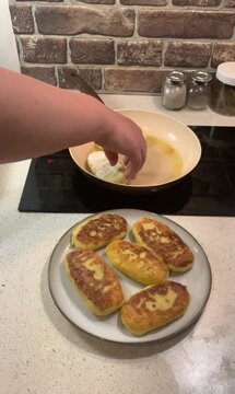 Perfect golden-brown crust! Close-up of flipping potato zrazy (stuffed potato pancakes) in a frying pan with oil. Cozy home cooking video.