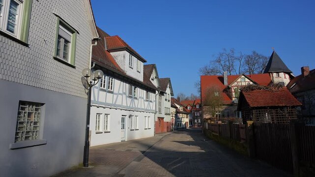 Gepflasterte Gasse ges&auml;umt von Fachwerkh&auml;usern, die einen klaren Himmel &uuml;berblickt, Am Schlossgraben, Erbach, Odenwald, Hessen, Deutschland