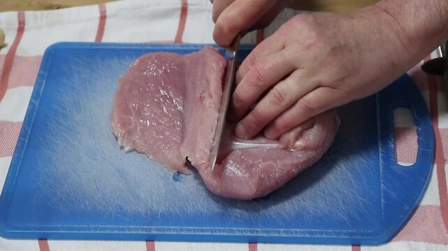 Cutting turkey breast for cooking, sideview