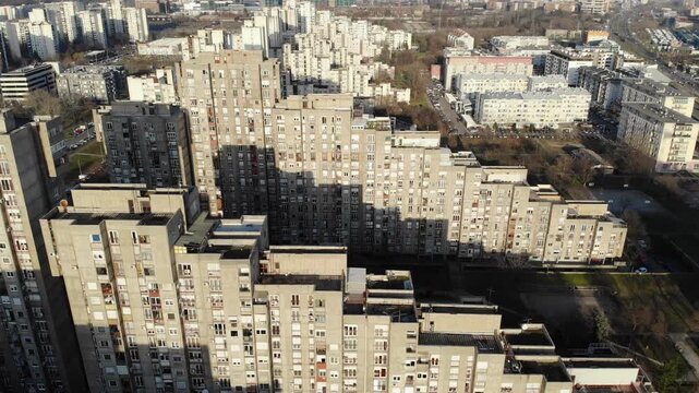Warm golden hour light on brutalist stepped residential buildings in New Belgrade, Serbia.