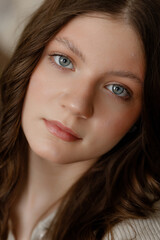 Naklejka premium Calm Caucasian Woman In Minimal Interior, Soft Window Light On Face, Ribbed Sweater Texture, Subtle Smile, Hand Resting Near Cheek, Relaxed Gaze Toward Camera, Cozy Warm Tones, Intimate