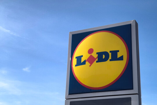 Estarreja, Portugal - 19.04.2026: Low angle view of Lidl supermarket sign against clear blue sky, illuminated by sunlight, representing retail shopping and branding on a bright sunny day outdoors