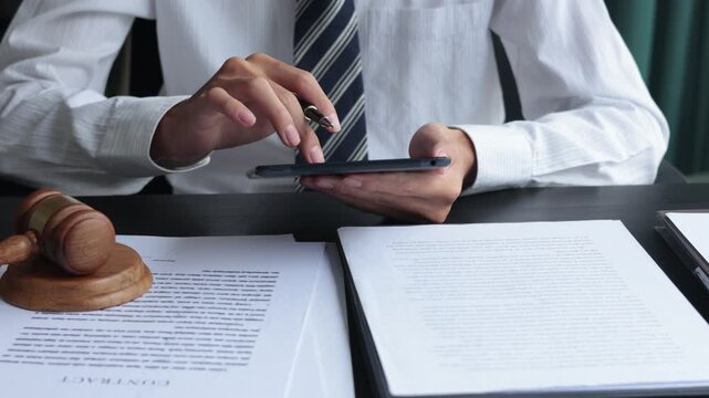 Lawyer working in office investigate the case by reading documents and using taplet.