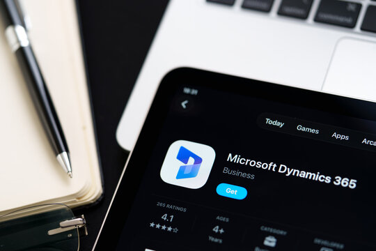 Microsoft Dynamics 365 logo on iPad in Apple Liquid Glass iOS 26 interface photographed on desk with pen and laptop. Stafford, United Kingdom, April 13, 2026.