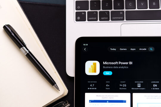 Microsoft Power BI listing on iPad highlights Apple Liquid Glass updated design and iOS 26 look in office desk scene. Stafford, United Kingdom, April 13, 2026.
