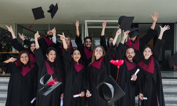 group of young Latinos graduates students throwing their graduation caps and celebrating at University campus in Mexico Latin America, portrait of Mexican people at college