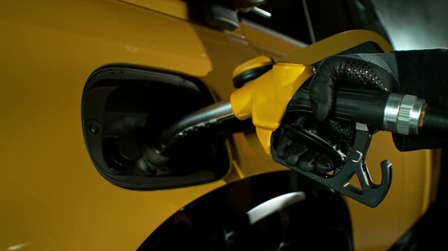 Close-up of a hand pouring gas into a car at a gas station. refueling the car's tank