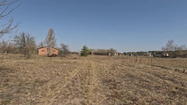 Solitary Farm Landscape. Isolated Rural Setting With Distant Structures Present. Secluded Country View Featuring Solitary Barn Surrounded By Expansive Greenery And Scattered Trees
