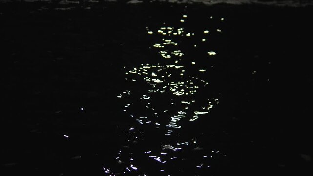 Moonlit Water Reflection Rippling In Darkness, Soft Golden Highlights Trail Across Black Lake Surface, Slow Rhythmic Motion Creates Meditative Mood, Subtle Shimmer And Serene Stillness Ideal
