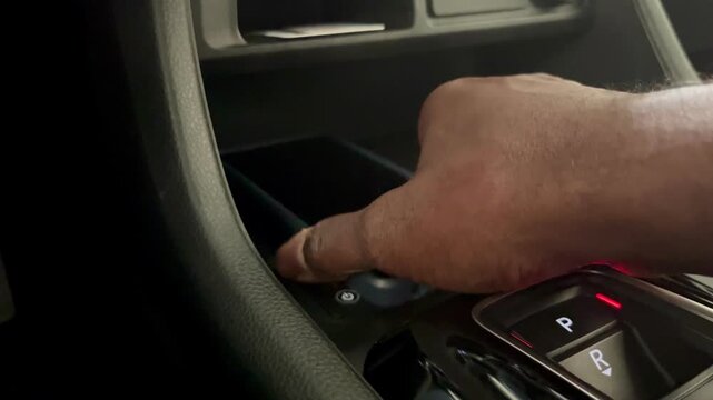 Hand placing smartphone on wireless charging pad in car