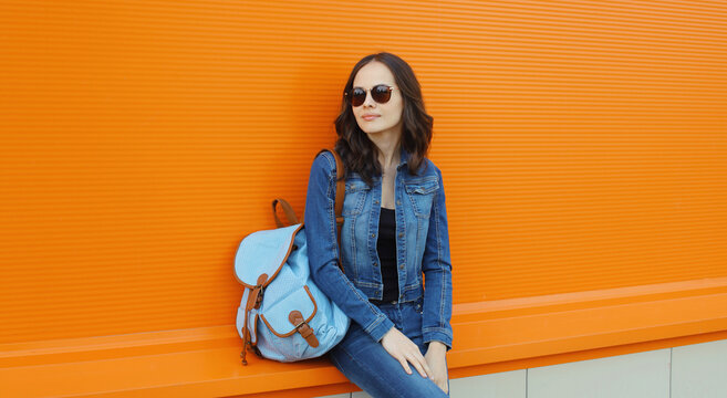 Young woman with backpack , modern teenage girl posing on city street