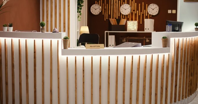 Rack focus shot of stylish travel vacation accommodation lounge interior with posh green furniture ready to welcome guests. Empty luxury hotel foyer with check in reception front desk