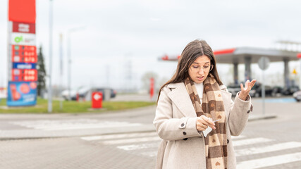 High gas prices woman reading receipt at station © Maksym