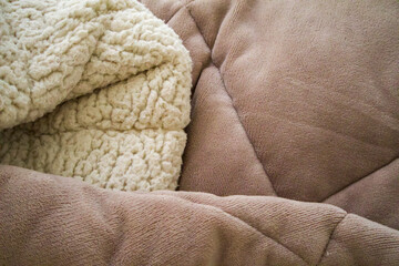 Close up of soft sherpa blanket with fleece texture. Cozy home comfort concept, warm fabric detail, minimal lifestyle background with soft light © Mariia
