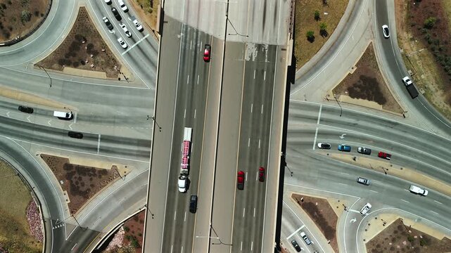 Direct overhead drone view of highway interchange with moving traffic