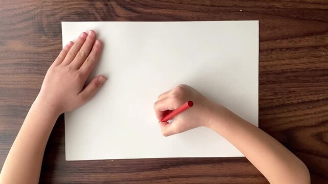 Child drawing a circle on A4 paper with red pen in slow motion, top view, no sound