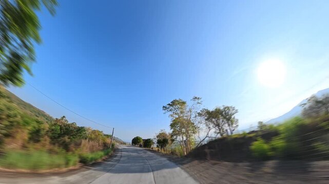 Scenic winding highway with mountain view has fast-paced effect with motion blur including surrounding sound