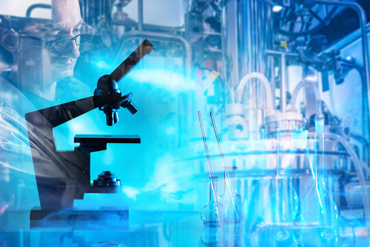 Biotechnology research, Bioreactor systems. Scientist studies samples with microscope near laboratory bioreactor equipment, conducting analysis and controlled cultivation processes.
