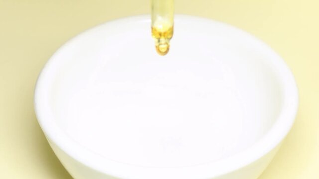 pipette putting cosmetic oli in a bowl