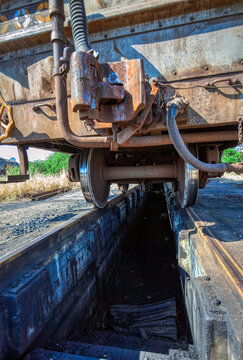 Close-up View of a Railway wagon coupling and steel wheels Carriage Over a Maintenance Pit