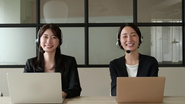カメラ目線で微笑むコールセンターの日本人女性