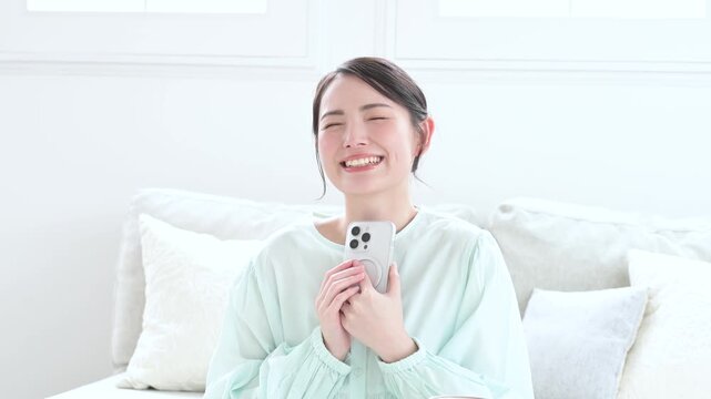 スマホを見て喜ぶ日本人女性