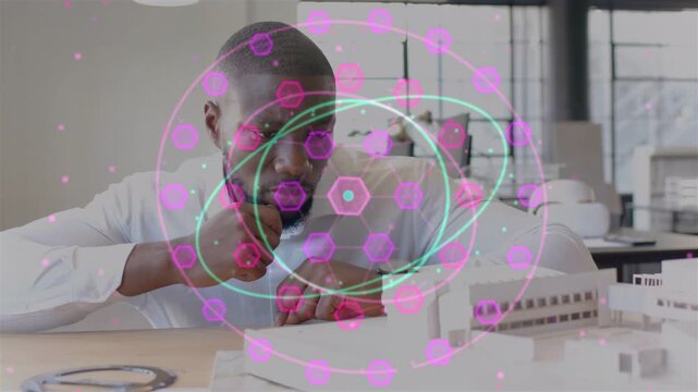 Designer studying scale model and tweaking causing pink hex  and  cyan rings growing and covering ha