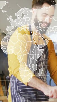 Vertical video: Baker leaning and kneading dough while world map overlaying baker, preparing dough