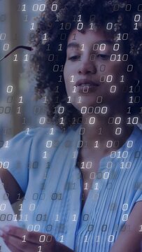 Woman lifting glasses reading report analyzing data in home office binary overlay covering face