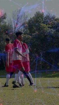 Vertical video: Soccer team forming breaking wall moving right defending cheering with bluepink net