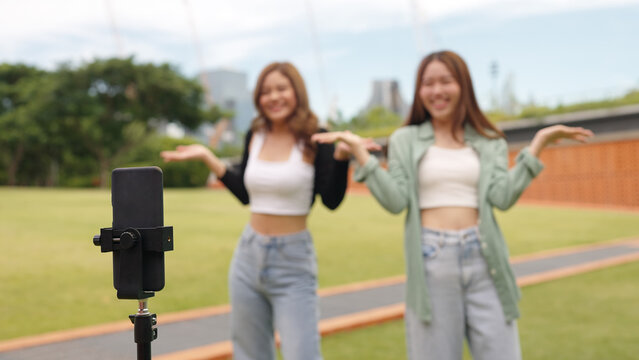 Gen z vlogger influencer asia teen girl trending relax smile moving dance at city park street record on IG reel tiktok instagram app young youtuber play fun joy selfie post show share viral vlog video