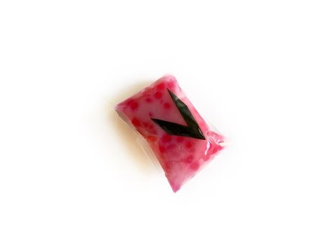 Jenang Mutiara, Indonesian traditional sweet porridge made of tapioca pearls with coconut milk, isolated on white background. Popular pink sago dessert for Ramadan iftar and cultural snacks.