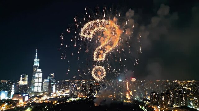 Fireworks display forming a question mark over a city skyline at night.
