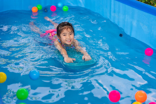 preschool child girl playing in swimming pool in backyard