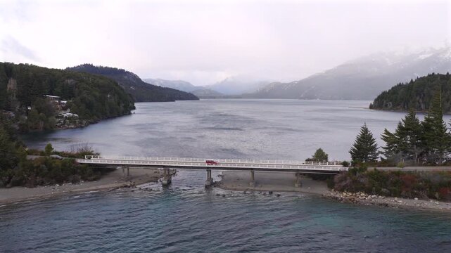 Aerial footage of snowfall over calm Playa sin Viento beach on Lake Perito Moreno in Circuito Chico, Bariloche, Argentina.