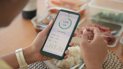 Young adult black asia people active gen z using AI phone record data daily meal tracker clean food diet app control. Asian Smart living care happy life goal routine plan lunch time home dining table. © ChayTee
