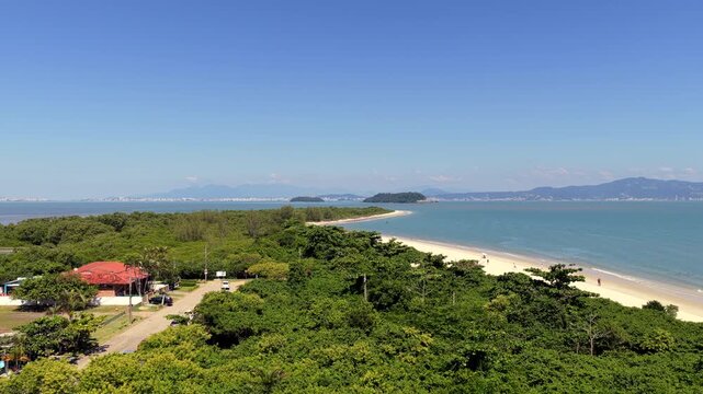 Scenic coastal reveal of Daniela Beach in Florianopolis, showcasing peaceful shoreline and tropical vacation destination.