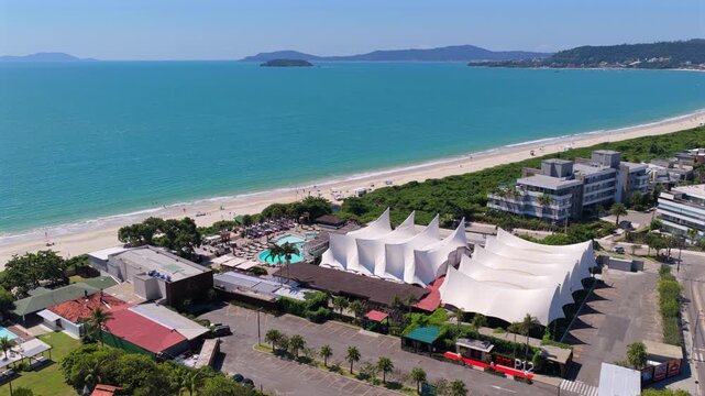 Aerial view of P12 beach club in Jurere Internacional with iconic white structure and ocean coastline.