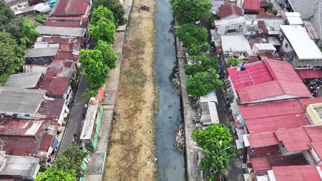 An blue excavator is working to digging the bottom of the jakarta river, Excavator with a long arm.  floating platform in a river digging cumulative dirt that shallowing the river