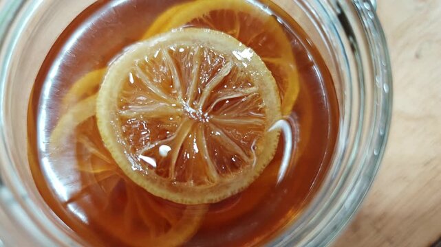 Lemons pickled in honey in a container.