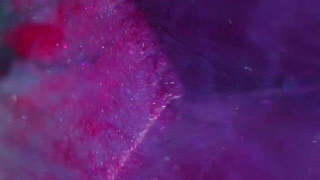 Vertical video. Sparkling smoke. Paint haze. Violet purple red fume spill art cube. Colorful water wave swirl pigment liquid abstract defocused background.