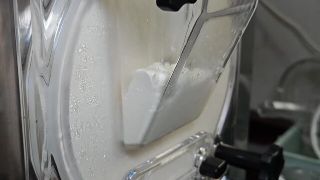 Ice cream maker machine. Ice cream falls into container.