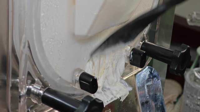 Ice cream maker machine. Ice cream falls into container.