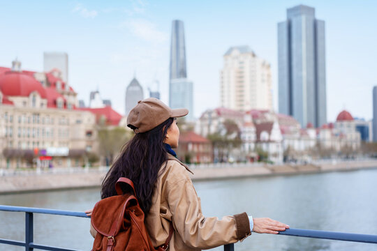 Happy Woman Traveler relaxes and enjoys the view of a Tianjin City with European-Style Architecture