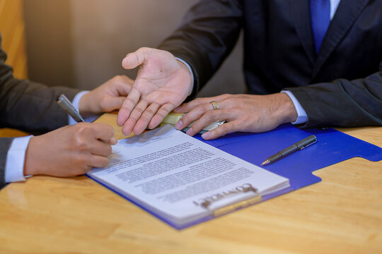 Businessman puts signature on contract at business meeting after negotiations with business partners. Selected focus