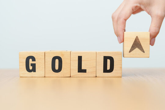 Hand change wood cube block with GOLD text to UP and Down arrow symbol icon.price, down and up, decrease and increase, cut loss, stocks, financial and economic concept