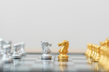 gold Chess knight figure and Checkmate opponent during chessboard competition. Strategy, Success, management, business planning, win, disruption, Trade war and leadership concept © Jo Panuwat D