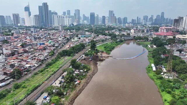 Aerial view The blue and yellow excavator is working to dig and clean the river from mud and rubbish, removing it to the edge of the river middle city